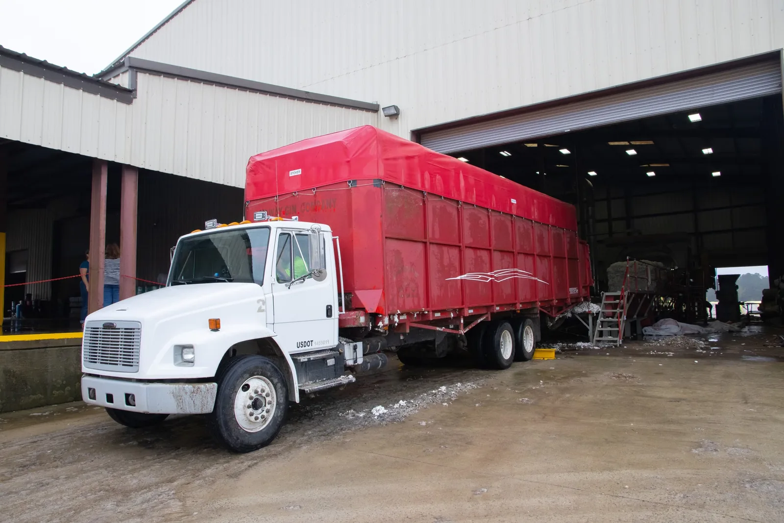 Representative industry photograph of a red trailer at a warehouse loading dock.